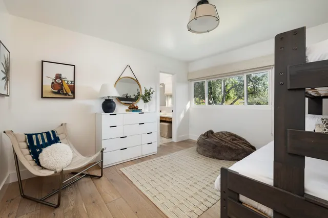 a bedroom with a bed and a flat tv screen on the dresser