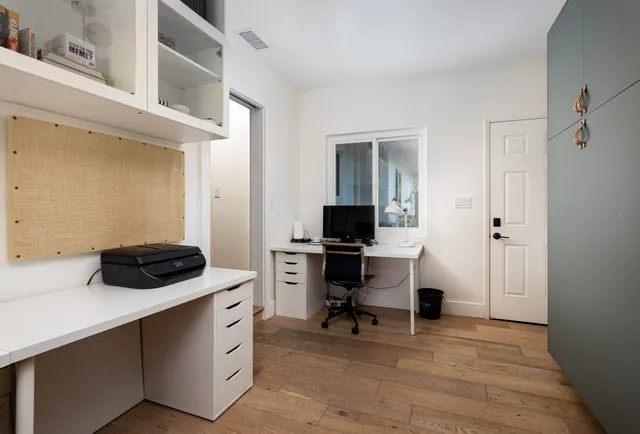 a view of a workspace with furniture and a window