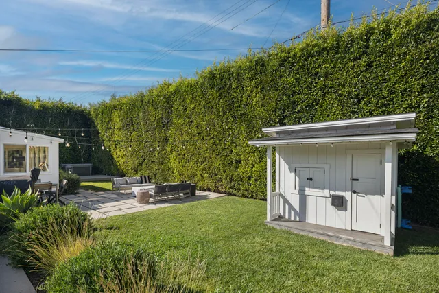 a view of a chair and tables in the back yard of the house