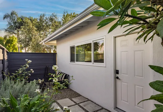 a wooden bench sitting in front of a house