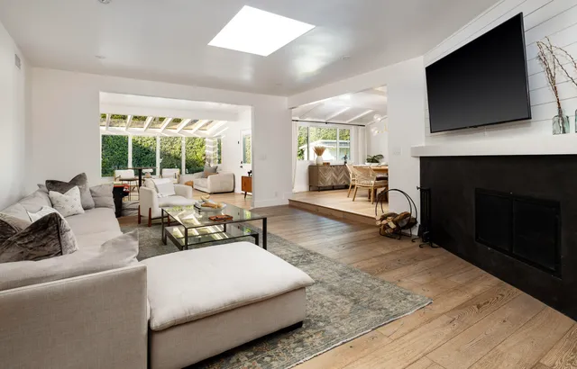 a living room with furniture a flat screen tv and a fireplace