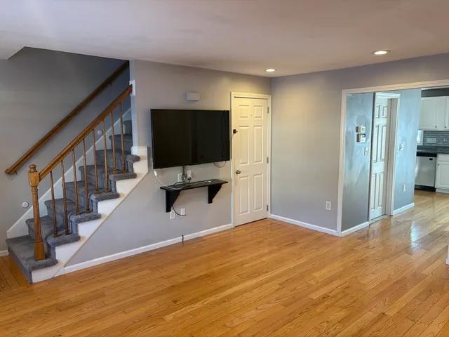 a view of a livingroom with wooden floor and furniture