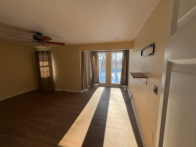 a view of a hallway with wooden floor and staircase
