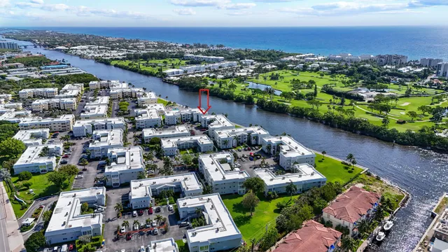 an aerial view of a city with lots of residential buildings ocean and mountain view in back