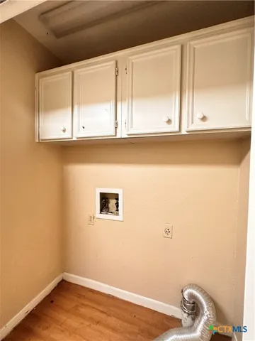 a view of a small space with wooden floor and a window