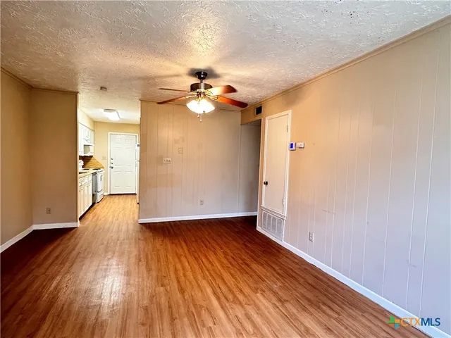 a view of empty room with wooden floor