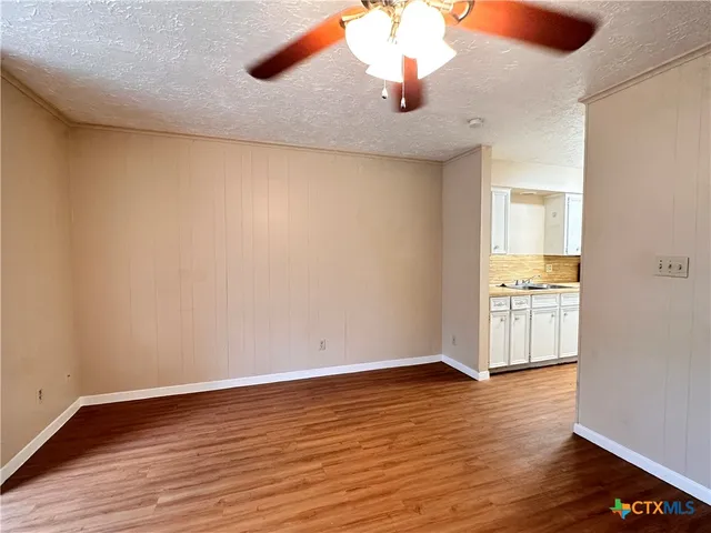 a view of an empty room with wooden floor