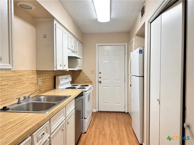 a kitchen with a sink stove and refrigerator