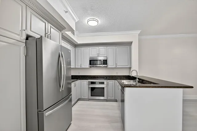a kitchen with granite countertop white cabinets and white appliances