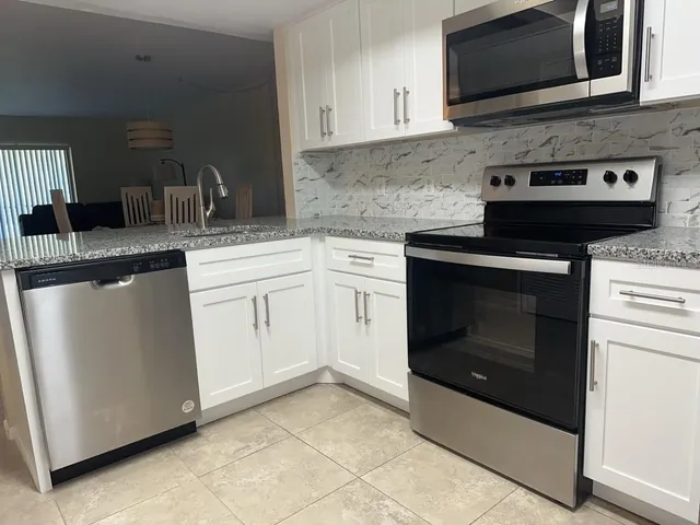a kitchen with cabinets stainless steel appliances and a sink