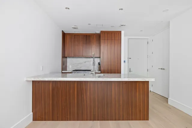 a kitchen with kitchen island a sink cabinets and wooden floor