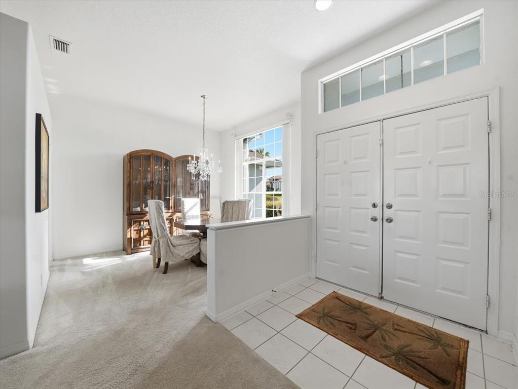 9311 Butler Boulevard Weeki Wachee, FL 34613 - Photo 18 of 60 a living room with furniture a window and a chandelier