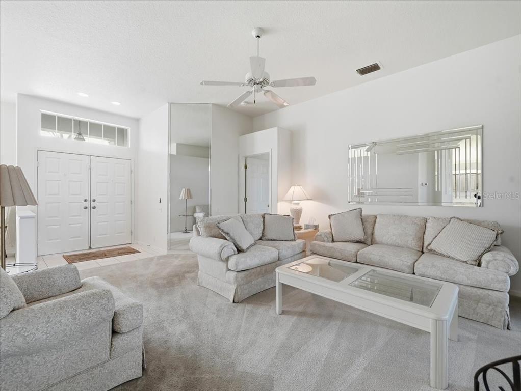 9311 Butler Boulevard Weeki Wachee, FL 34613 - Photo 24 of 60 a living room with furniture and a chandelier