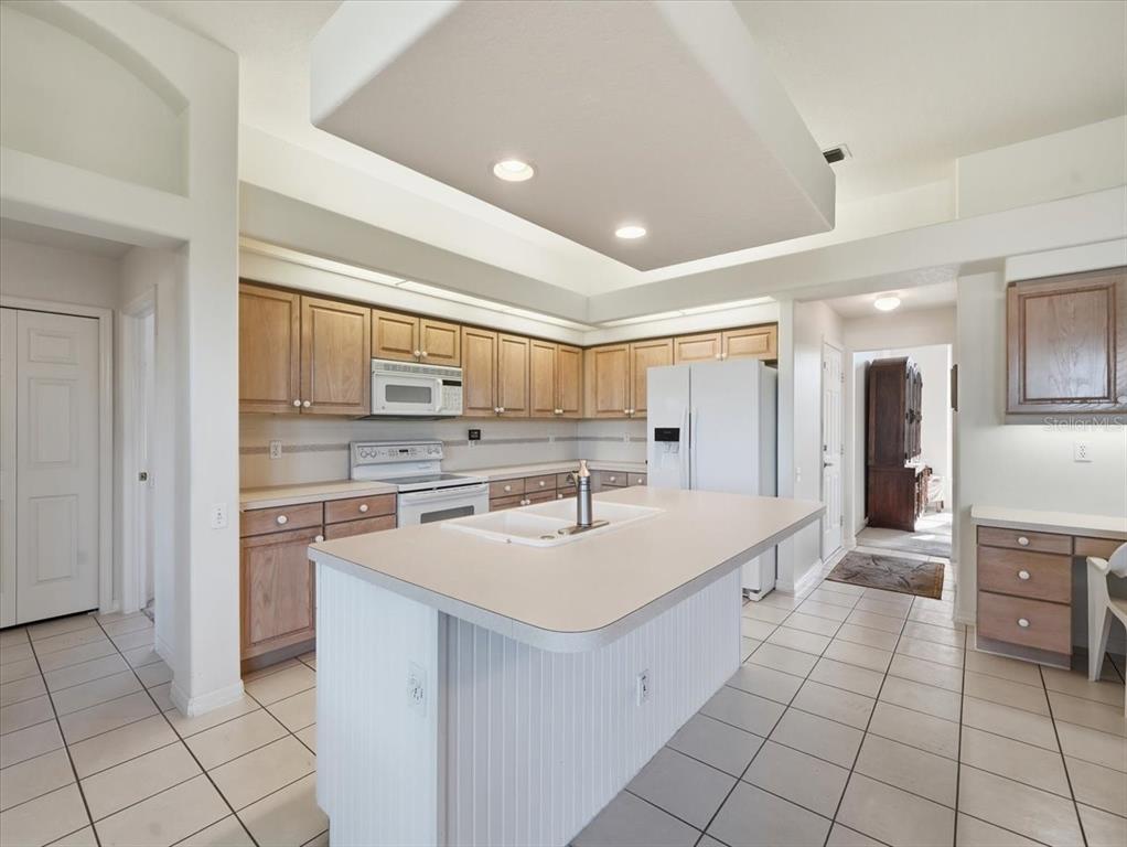 9311 Butler Boulevard Weeki Wachee, FL 34613 - Photo 30 of 60 a large white kitchen with a sink and cabinets