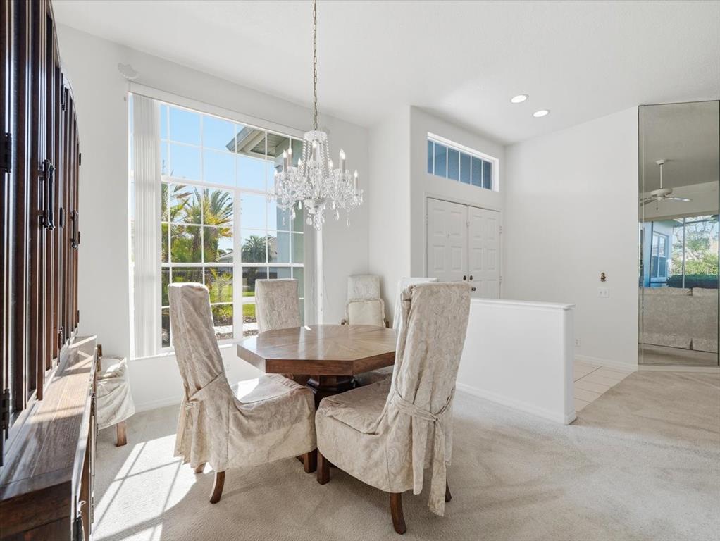 9311 Butler Boulevard Weeki Wachee, FL 34613 - Photo 39 of 60 a dining room with furniture a chandelier and wooden floor