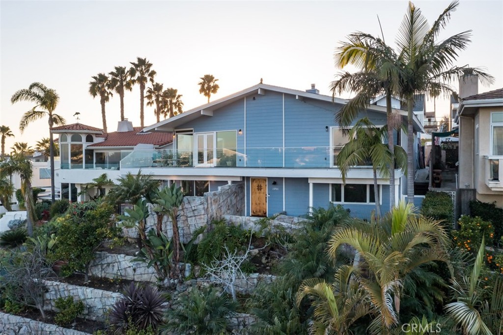 a front view of a house with a yard and potted plants