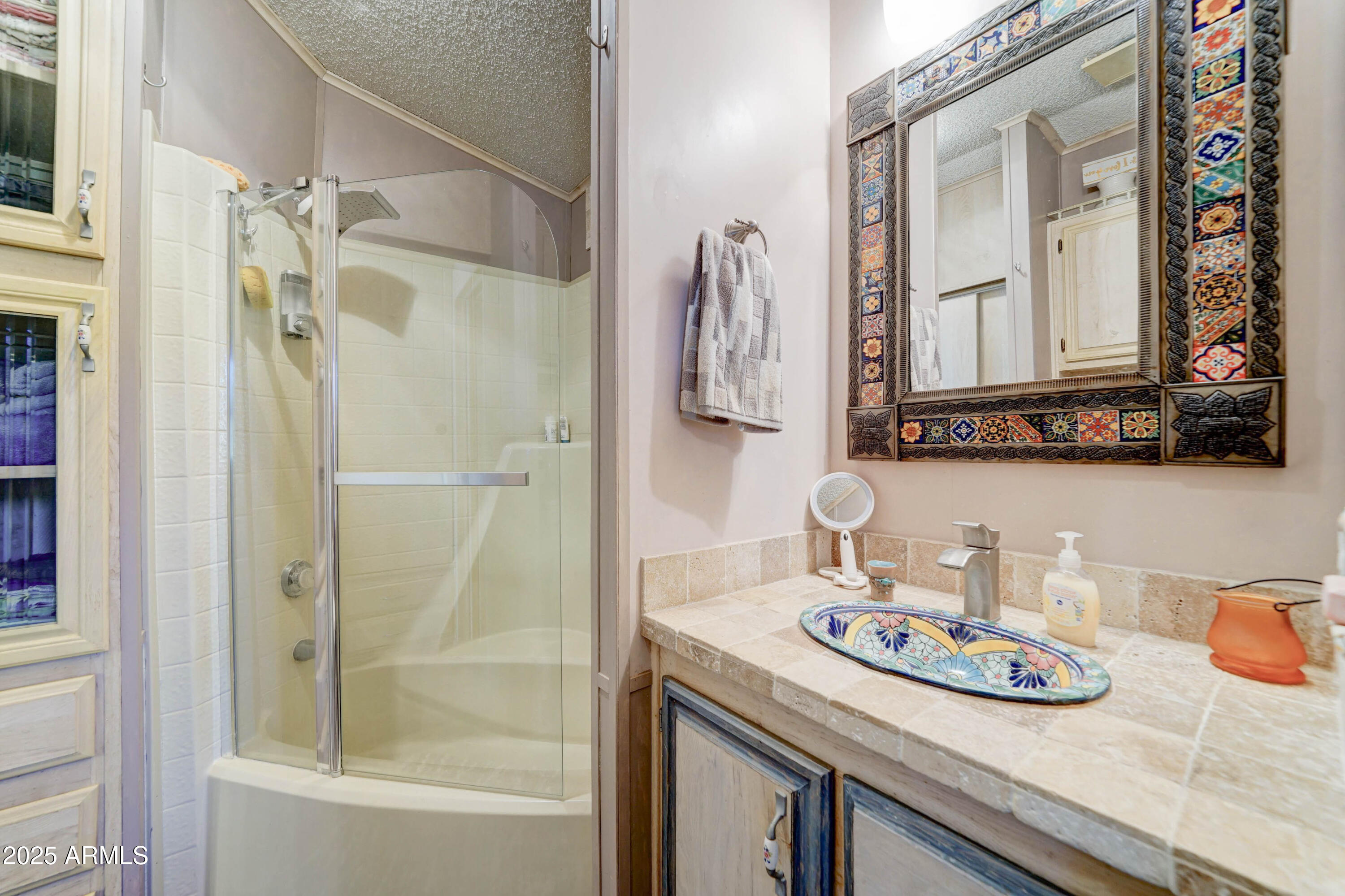 111 South Greenfield Road, Unit 633 Mesa, AZ 85206 - Photo 17 of 32 a bathroom with a granite countertop sink a mirror and shower
