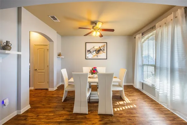 a dining room with wooden floor and a chandelier