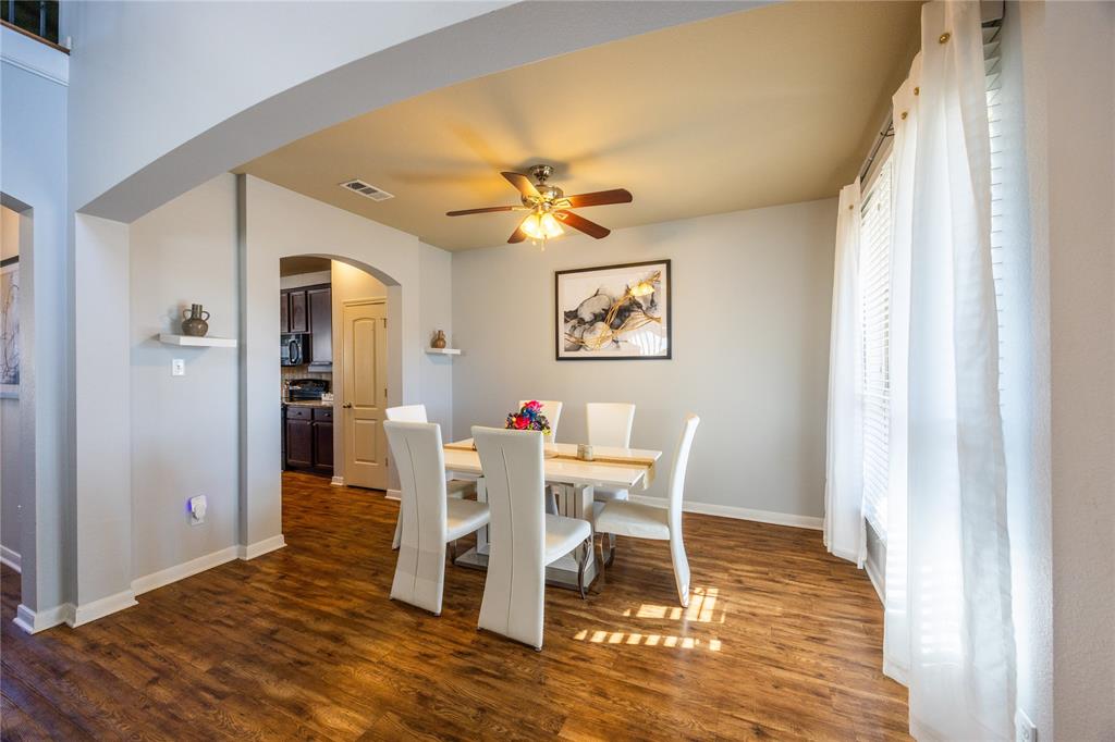 10864 Aurora Drive Waco, TX 76708 - Photo 16 of 40 a dining room with wooden floor and a chandelier