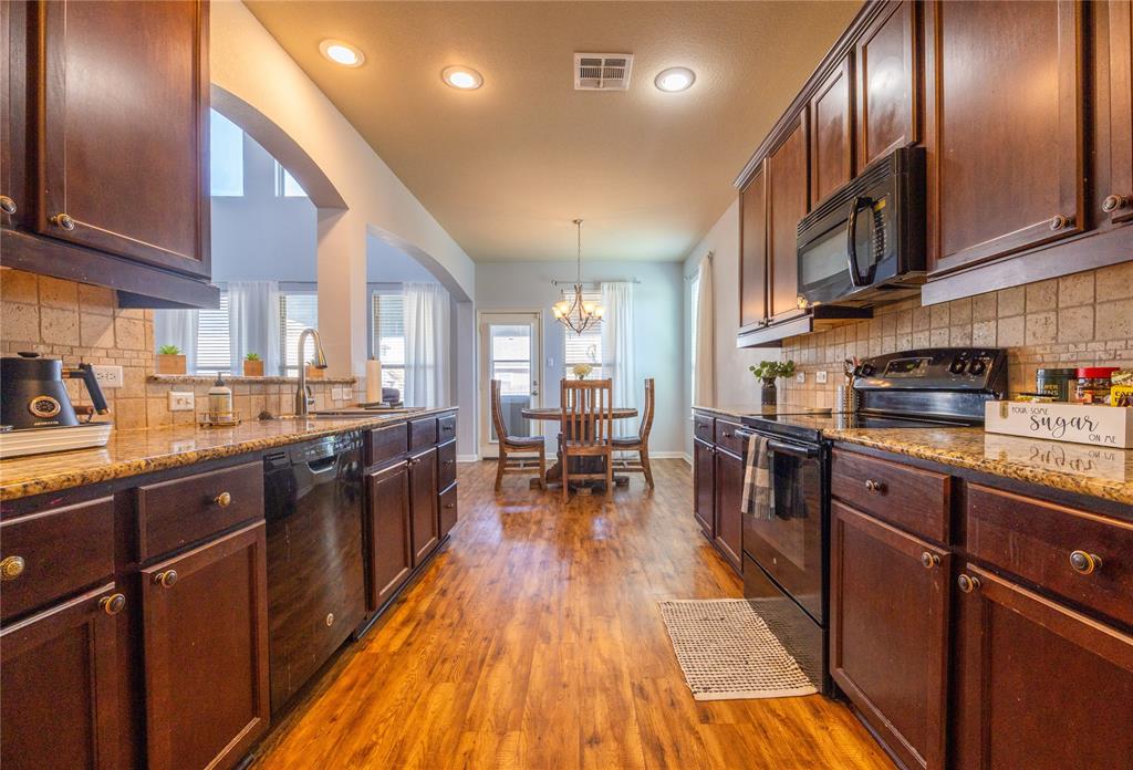 10864 Aurora Drive Waco, TX 76708 - Photo 22 of 40 a kitchen with stainless steel appliances granite countertop lots of counter top space a sink and a wooden floors