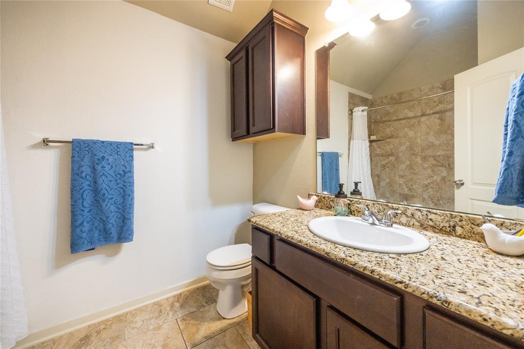 10864 Aurora Drive Waco, TX 76708 - Photo 28 of 40 a bathroom with a granite countertop sink and a mirror with toilet