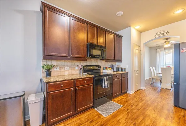 a bedroom with a bed a chair and a dresser next to a window