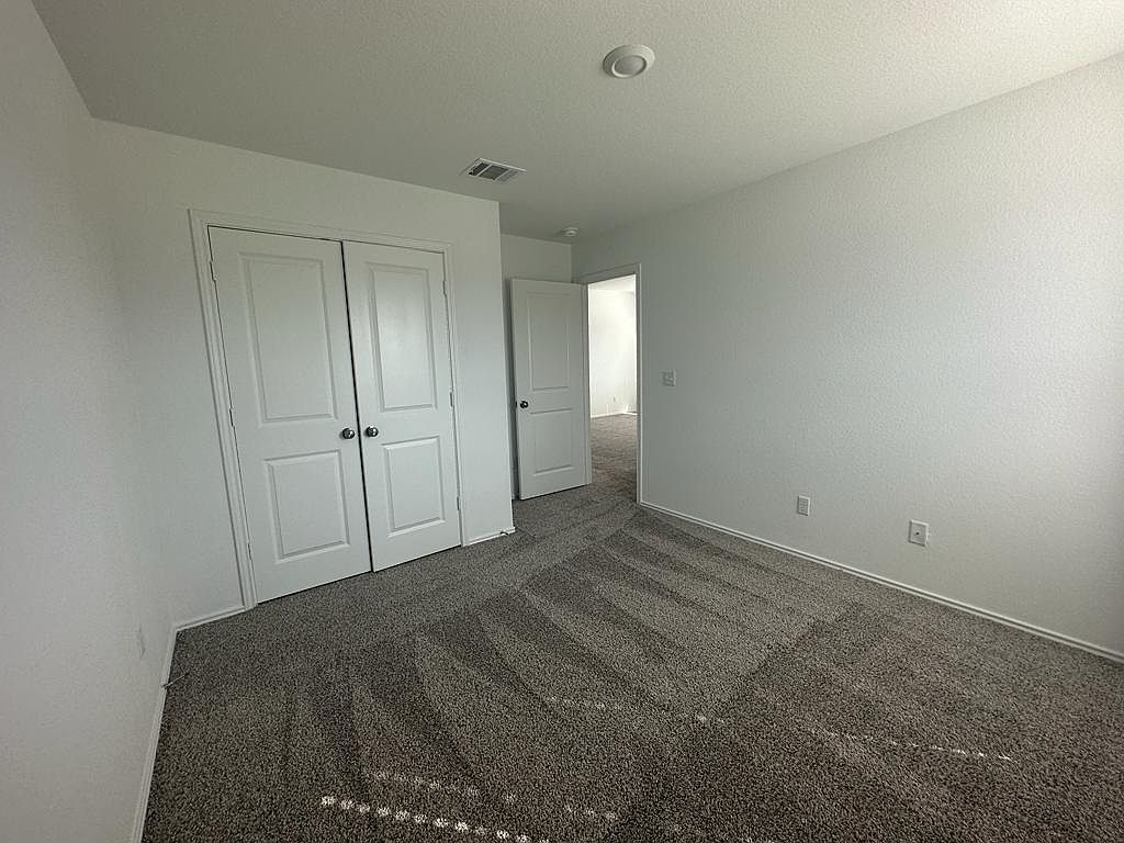 160 River Rise Road Kyle, TX 78640 - Photo 11 of 35 Neutral-toned wall-to-wall carpeting and crisp white walls