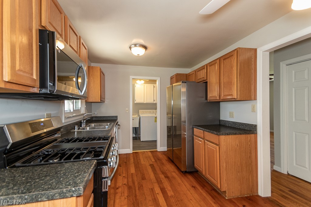 308 Wilson Mills Road Chardon, OH 44024 - Photo 11 of 21 Kitchen with stainless steel appliances, dark hardwood / wood-style flooring, washer / dryer, and sink