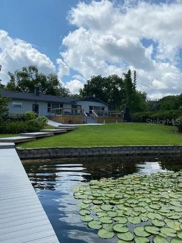a view of a backyard with plants and lake