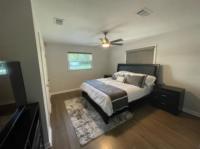 a bedroom with a bed and a flat tv screen on a dresser