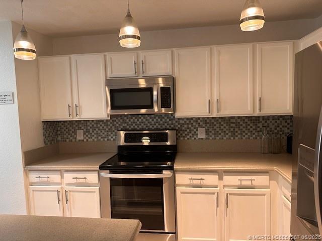 324 Southeast Bloxham Way Stuart, FL 34997 - Photo 14 of 35 a kitchen with stainless steel appliances granite countertop a stove a microwave a sink and cabinets