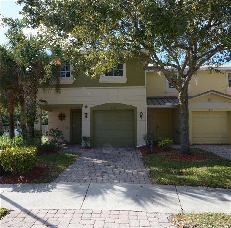 324 Southeast Bloxham Way Stuart, FL 34997 - Photo 2 of 35 a front view of a house with garden