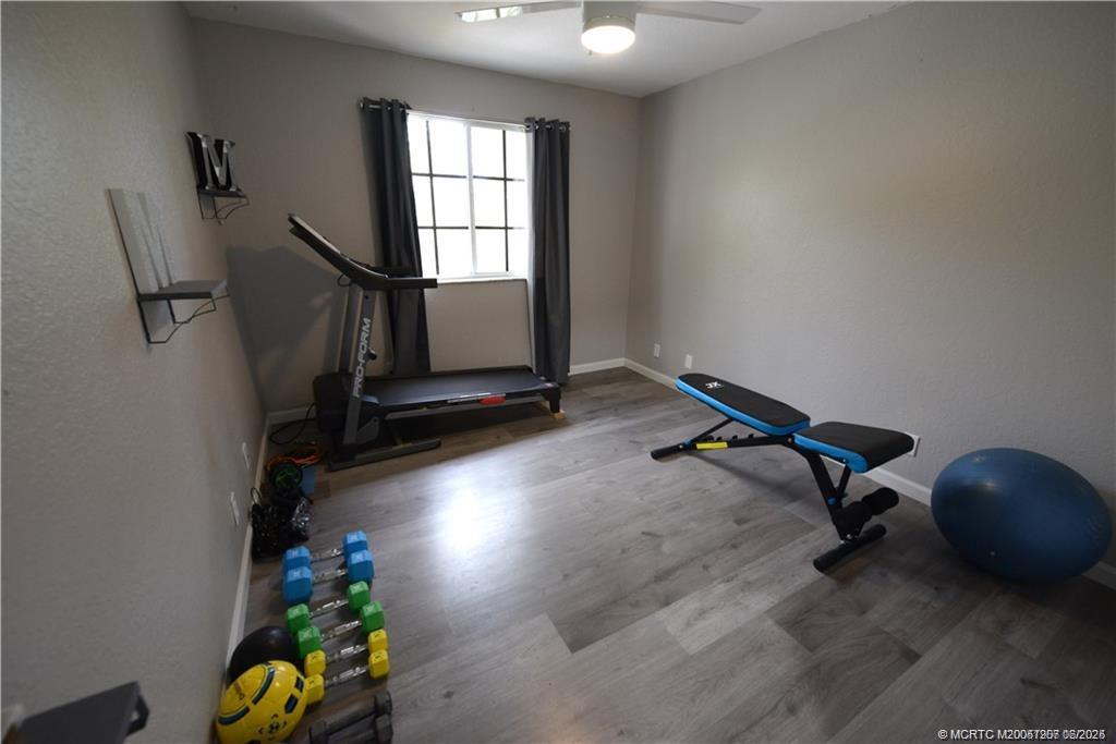 324 Southeast Bloxham Way Stuart, FL 34997 - Photo 22 of 35 a room with gym equipment and windows