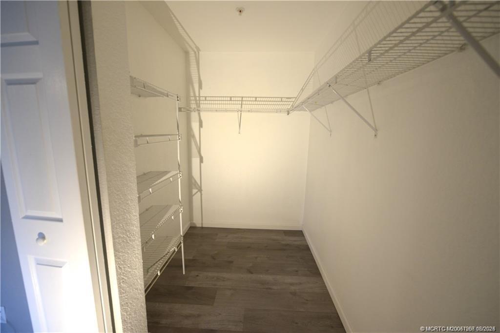 324 Southeast Bloxham Way Stuart, FL 34997 - Photo 25 of 35 an empty room with wooden floor and entrance