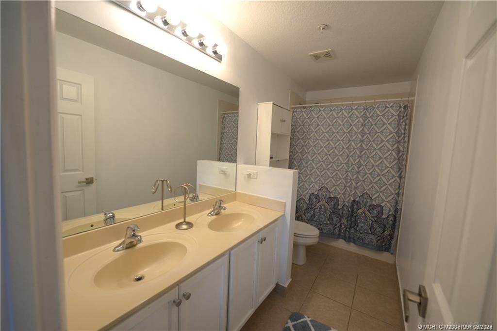 324 Southeast Bloxham Way Stuart, FL 34997 - Photo 26 of 35 a bathroom with a sink a toilet and shower