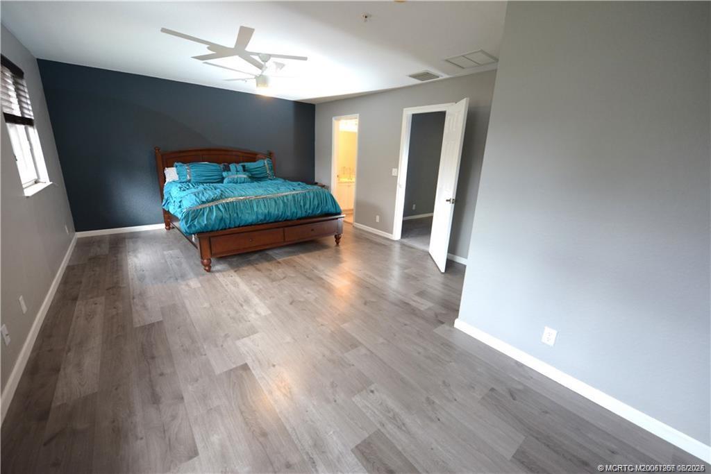 324 Southeast Bloxham Way Stuart, FL 34997 - Photo 27 of 35 a room with wooden floors and a ceiling fan