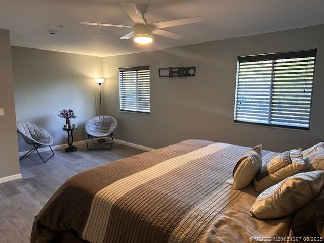 324 Southeast Bloxham Way Stuart, FL 34997 - Photo 5 of 35 a bedroom with a bed and wooden floor