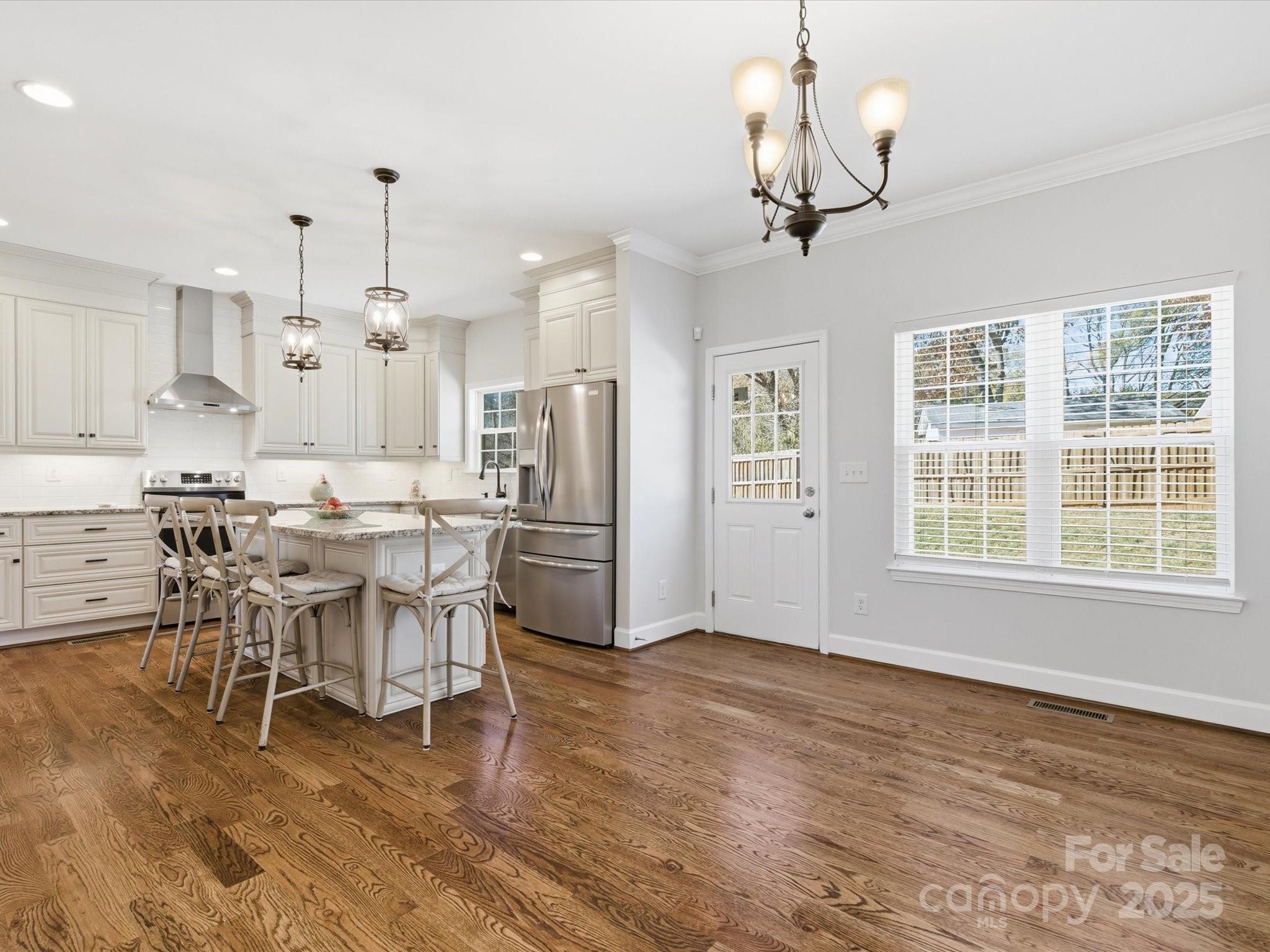 3211 Oakdale Road Charlotte, NC 28216 - Photo 13 of 43 a view of a dining room and livingroom with furniture wooden floor a chandelier