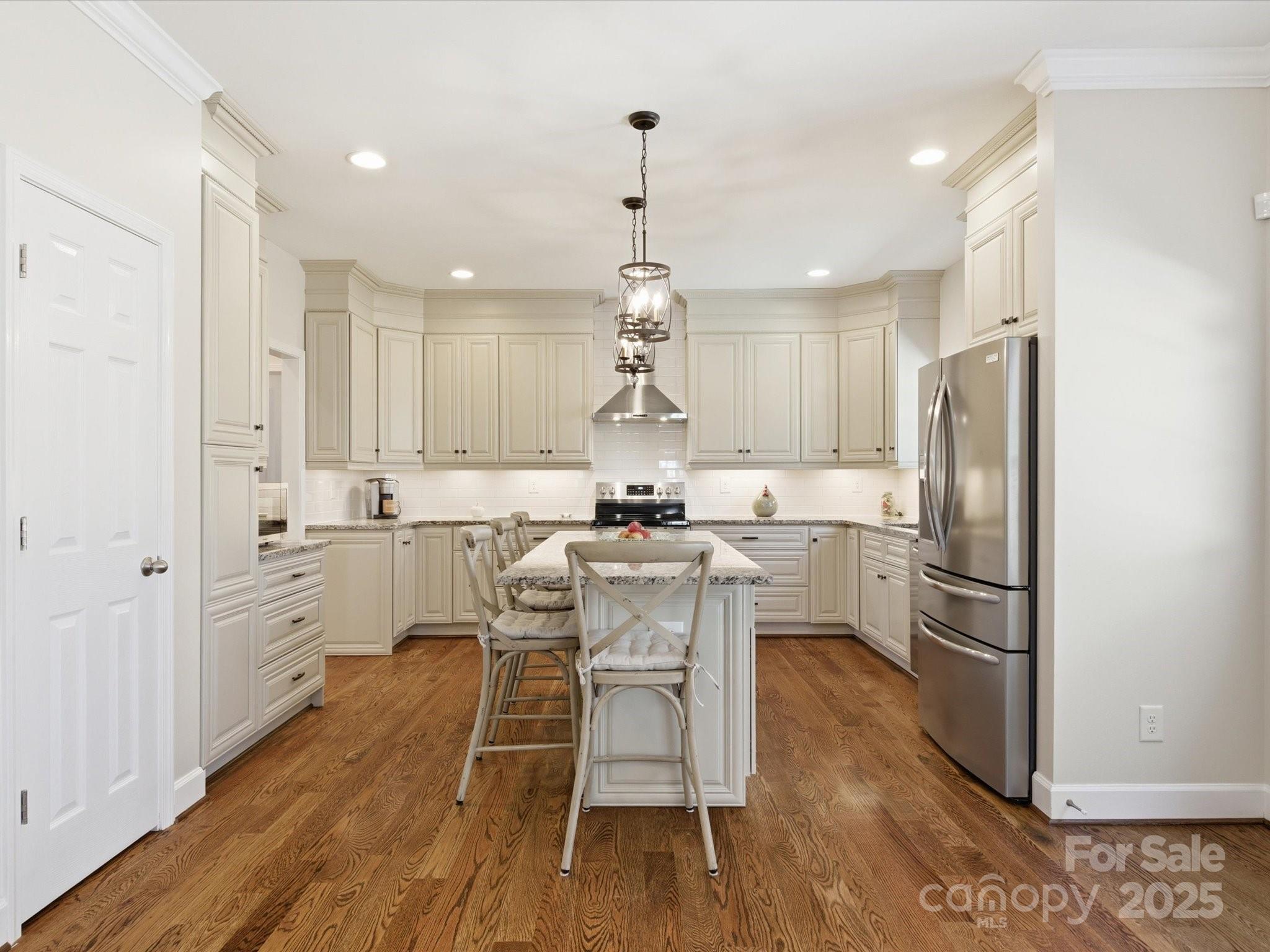3211 Oakdale Road Charlotte, NC 28216 - Photo 14 of 43 a kitchen with a refrigerator a white cabinets and wooden floor