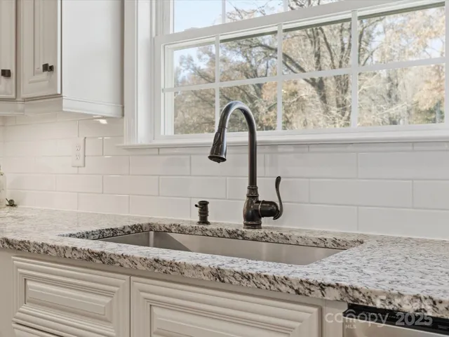 a kitchen with granite countertop a sink and a window