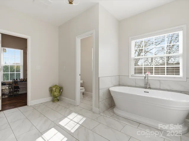 a spacious bathroom with a bathtub and next to a window