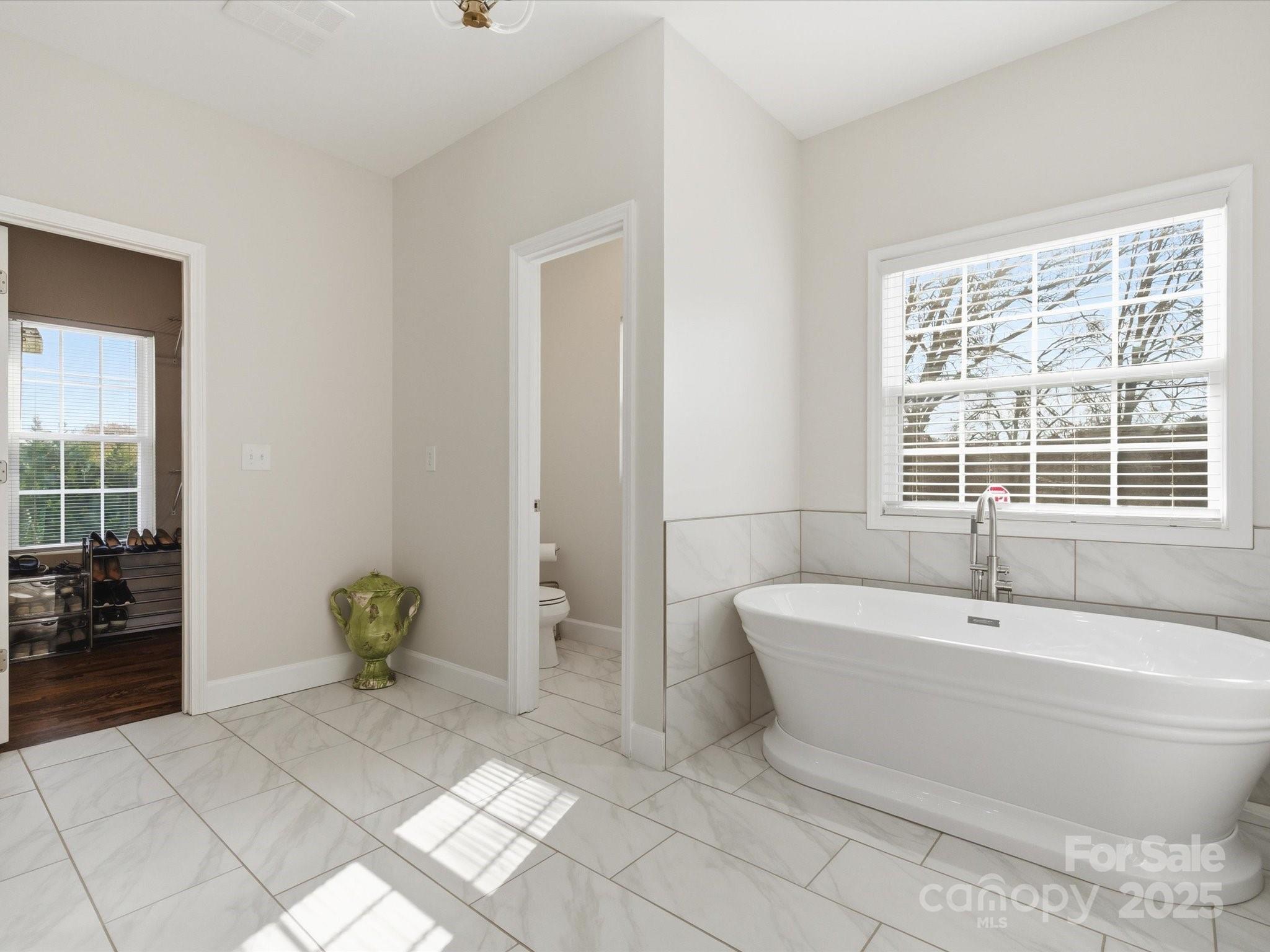 3211 Oakdale Road Charlotte, NC 28216 - Photo 24 of 43 a spacious bathroom with a bathtub and next to a window