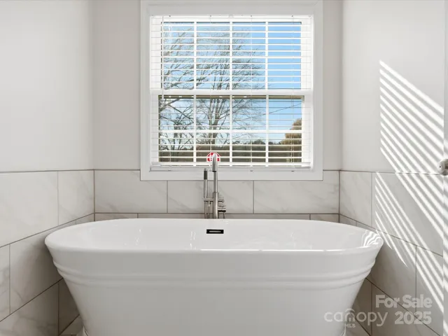 a white bath tub sitting next to a window