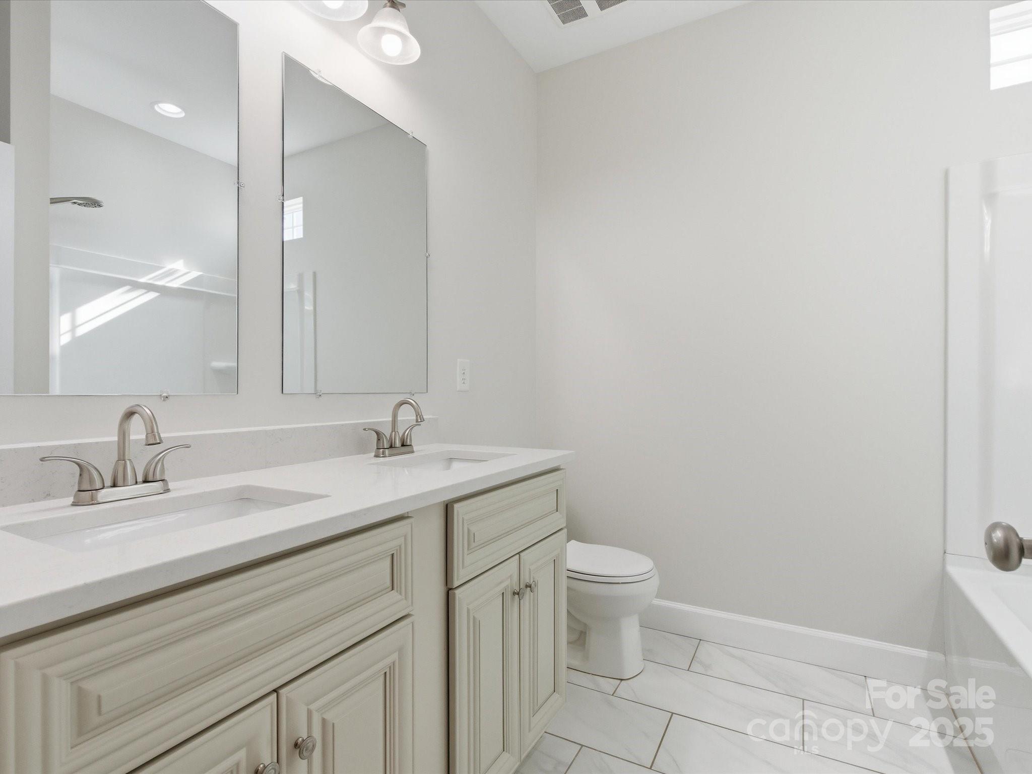 3211 Oakdale Road Charlotte, NC 28216 - Photo 35 of 43 a bathroom with a granite countertop sink a toilet and a mirror