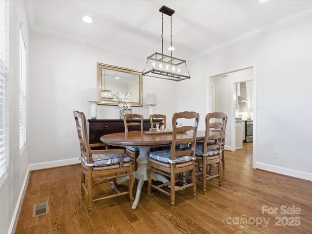 a view of a dining room with furniture a chandelier and wooden floor