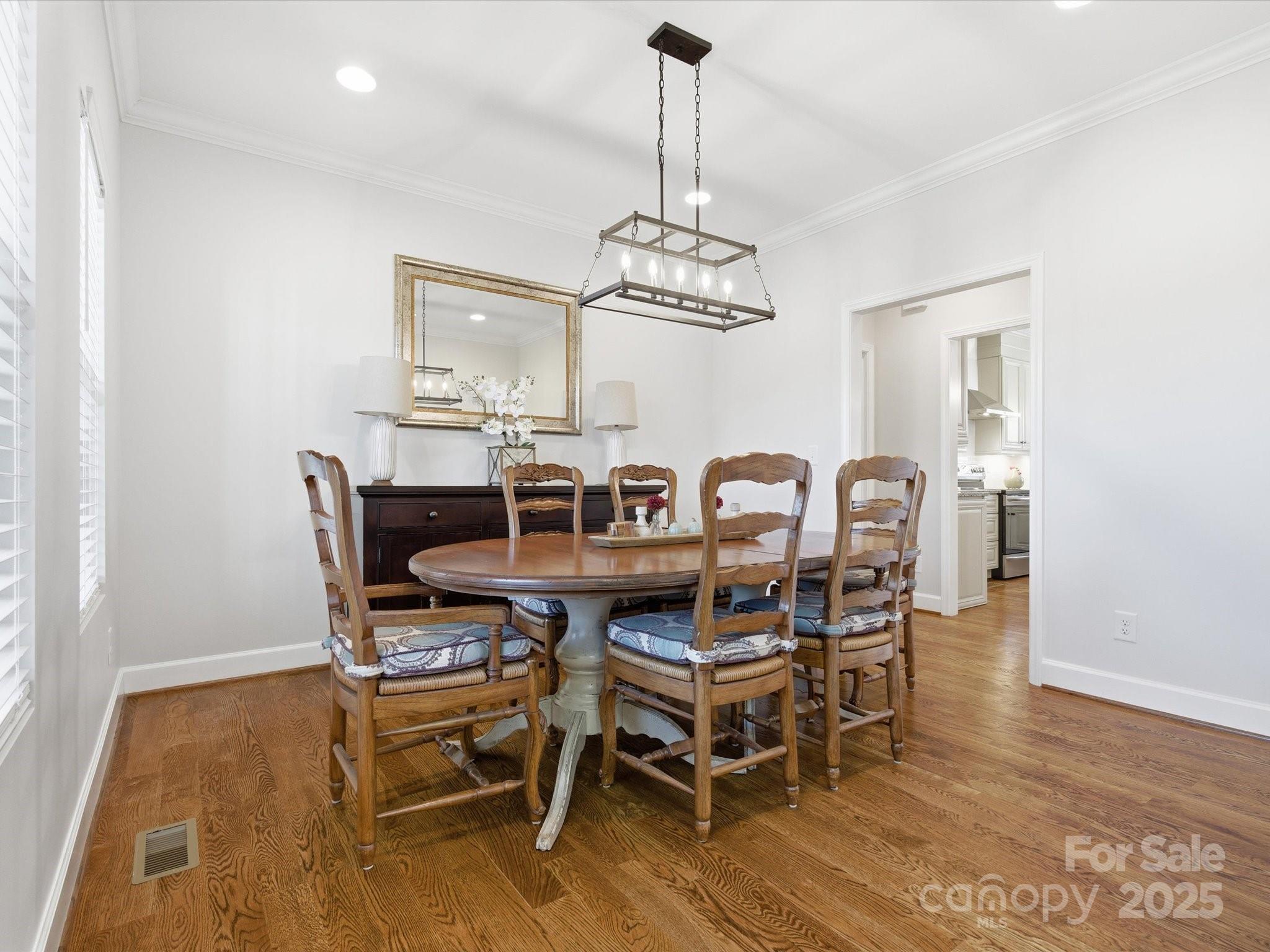 3211 Oakdale Road Charlotte, NC 28216 - Photo 5 of 43 a view of a dining room with furniture a chandelier and wooden floor