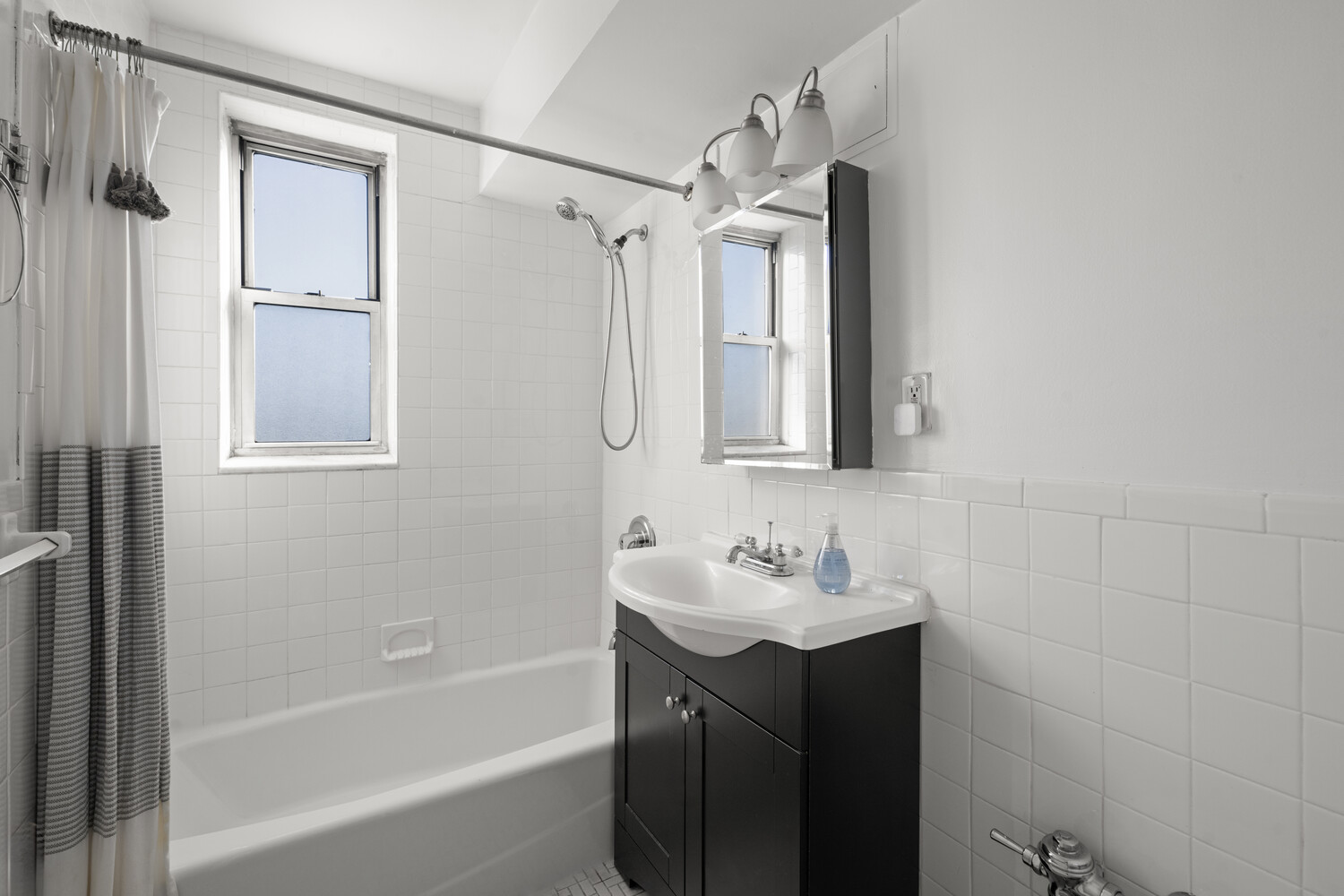 3512 Oxford Avenue, Unit 6C Bronx, NY 10463 - Photo 10 of 12 a bathroom with a tub sink vanity and mirror