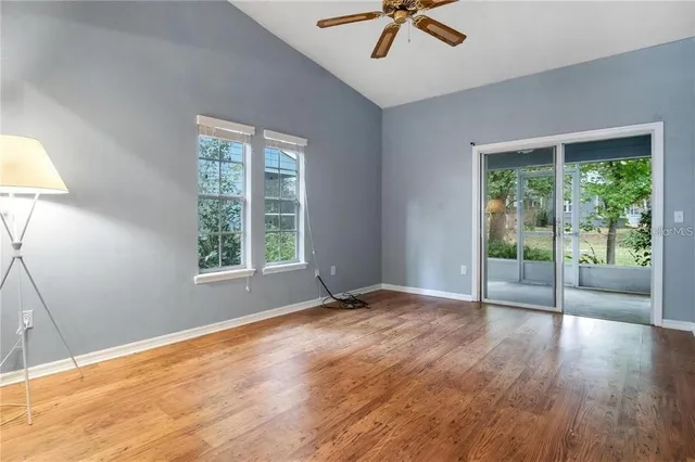 a view of an empty room with a window and wooden floor