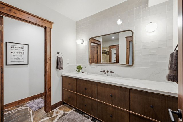 7885 North Rabbitbrush Court, Unit 13 Park City, UT 84098 - Photo 54 of 88 Bathroom featuring a wood-finish vanity with ample storage, a light-toned countertop, and a wall-mounted faucet