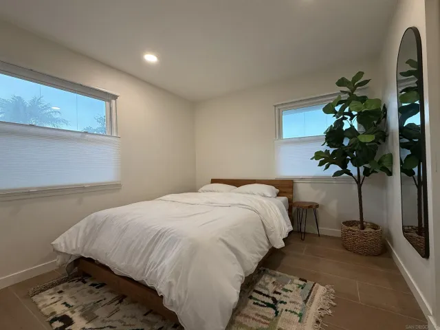 a bedroom with a bed and a potted plant